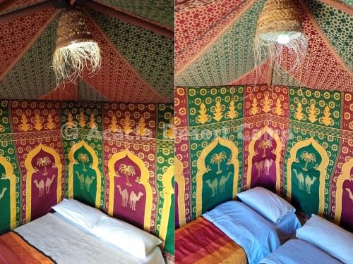 a room with a colorful wall with a bed in it at Acacia Desert Camp in Merzouga