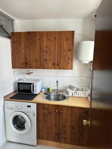 una cocina con fregadero y lavadora en Vientos de Alcornoque, en Alcalá de los Gazules