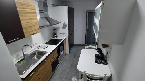 Una pequeña cocina con fregadero y encimera. en CASA JOSE "Acogedor Apartamento cerca de la playa", en Candelaria