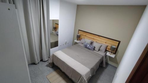 Un dormitorio pequeño con una cama y un espejo. en CASA JOSE "Acogedor Apartamento cerca de la playa", en Candelaria
