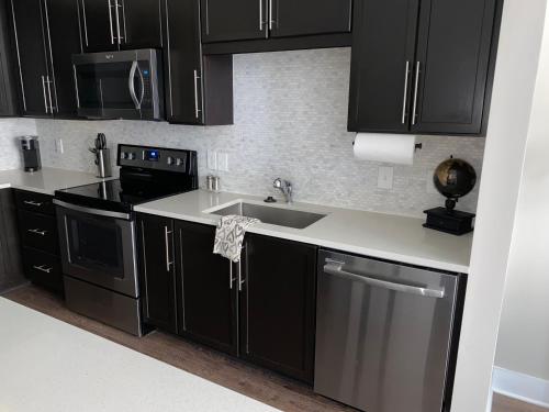 a kitchen with black cabinets and a sink at CozyN Buckhead in Atlanta