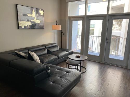 a living room with a leather couch and a table at CozyN Buckhead in Atlanta