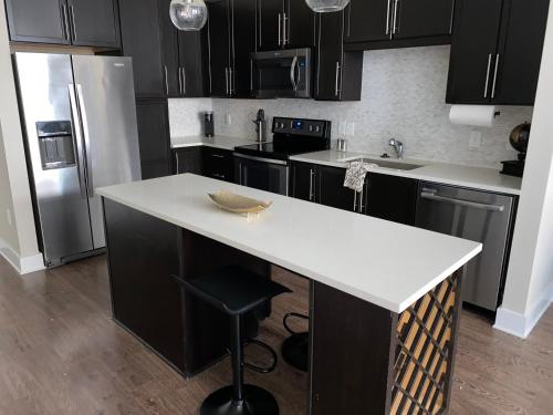 uma cozinha com armários pretos e um balcão branco em CozyN Buckhead em Atlanta