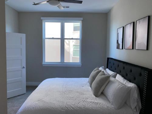 a bedroom with a bed with a ceiling fan and a window at CozyN Buckhead in Atlanta