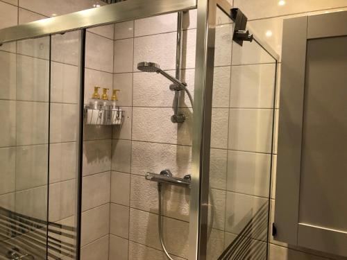a shower with a glass door in a bathroom at Amber in Gdańsk