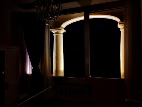 ein Fenster mit einer Säule in einem dunklen Raum in der Unterkunft Arena and Opera Love - Historic House Amorino at "Palazzo Tiolo" Palace in Verona