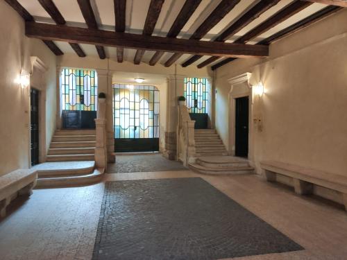 einen Flur mit Treppen und Buntglasfenstern in der Unterkunft Arena and Opera Love - Historic House Amorino at "Palazzo Tiolo" Palace in Verona