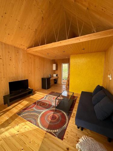 a living room with a couch and a rug at Sunny Houses domki rekreacyjne in Sobótka