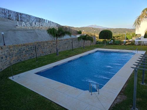 una piscina en un patio junto a una pared en Apartamento Las Abejeras en Estepona