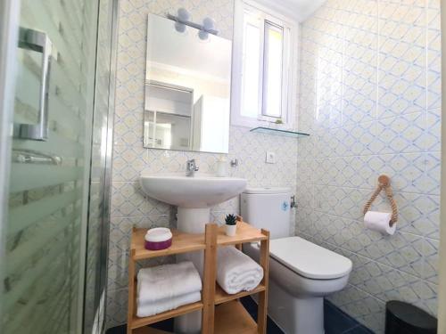 een badkamer met een wastafel, een toilet en een spiegel bij Coqueto Estudio en Los Maites in Benalmádena