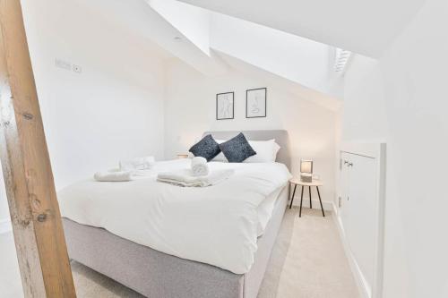 a white bedroom with a large white bed and a table at Modern 2 Bedroom Apartment in Central Nottingham in Nottingham