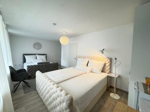 a bedroom with a large white bed and a chair at Deluxe Unterkunft in Bonn in Bonn