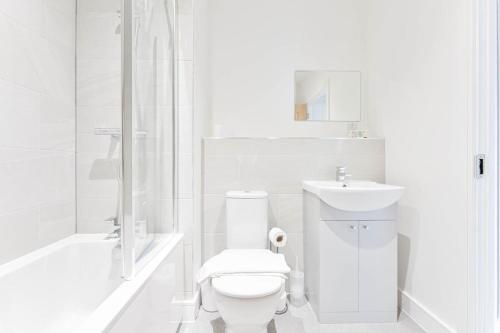 a white bathroom with a toilet and a sink at Modern 2 Bedroom Apartment in Central Nottingham in Nottingham