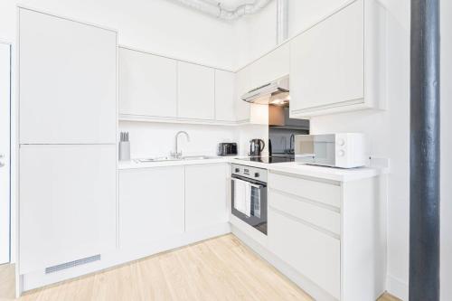 a white kitchen with white cabinets and appliances at Characterful 1 Bed Apartment in Central Nottingham in Nottingham