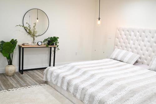 um quarto branco com uma cama e um espelho em Modern cozy home, pet friendly em Wolcott