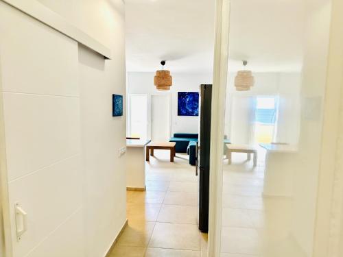a hallway with white walls and a living room at Pambnb - Modern Beachfront Apartment Hideaway in Santa Cruz de Tenerife