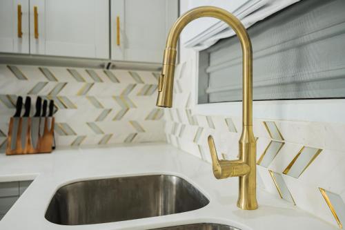 a kitchen sink with a gold faucet at Villa 409C in Jolly Harbour