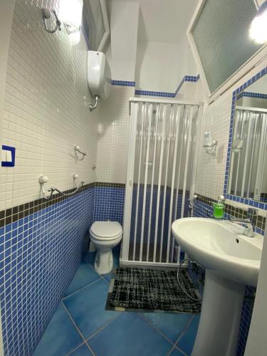 a blue and white bathroom with a toilet and a sink at Casa Vacanza IMPARO B&B Ischia in Ischia