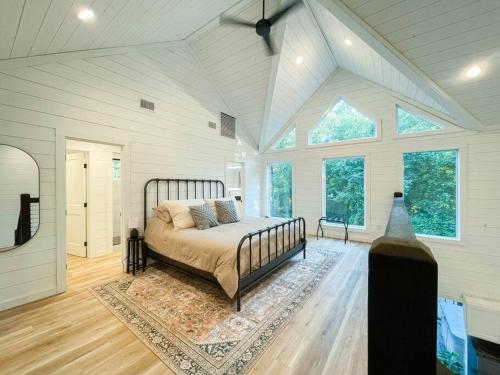 a bedroom with a bed in a room with windows at the RISER - BRAND NEW Modern Cabin in Broken Bow in Broken Bow