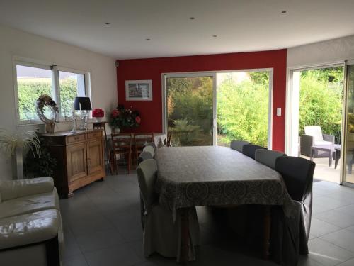 une salle à manger avec une table et des chaises et une cuisine dans l'établissement Les Jardins d Isaac rue de la Musardière, au Mans