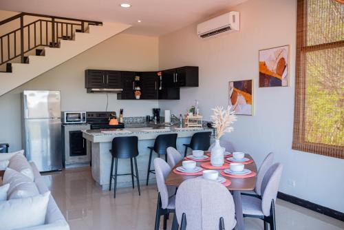 cocina y sala de estar con mesa y sillas en Sunset Harmony, Your Escape at Playa Hermosa, en Sardinal