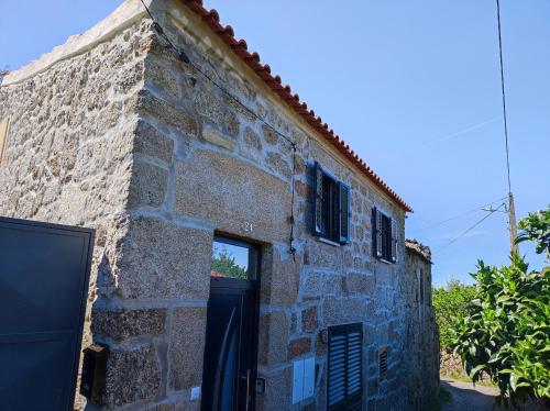 an old stone building with a door and a window at Casa da Martha in Celorico da Beira
