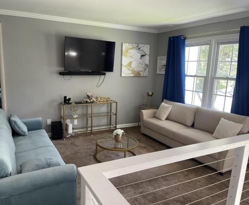 a living room with a couch and a tv at Homely & Alluring 5 bedrooms in Atlanta in Atlanta
