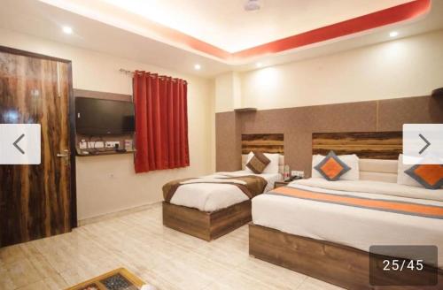 a hotel room with two beds and a television at THE RED DIAMOND NEAR IGI AIRPORT new DELHI in New Delhi