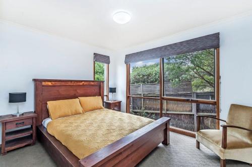 a bedroom with a bed and a large window at Beachview Bungalow Warrnambool in Warrnambool