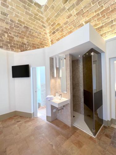 a bathroom with a sink and a mirror and a television at RESIDENZA ORTENSIA in Petacciato