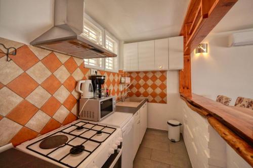 a small kitchen with a stove and a microwave at Apartmani Antony in Zaton