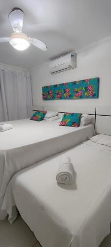 two beds sitting next to each other in a room at Solar de Manguinhos Flat in Manguinhos