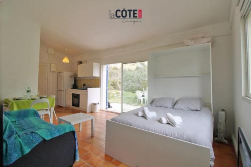 une chambre avec un grand lit et une cuisine dans l'établissement Les figuiers - 4 couchages, à Carry-le-Rouet