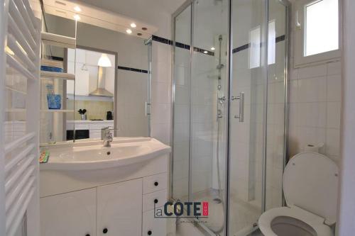 une salle de bain blanche avec un lavabo et une douche dans l'établissement Les figuiers - 4 couchages, à Carry-le-Rouet