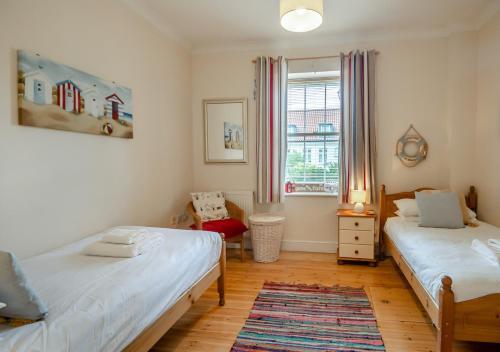Blythburgh的住宿－Wagtails，一间卧室设有两张床和窗户。
