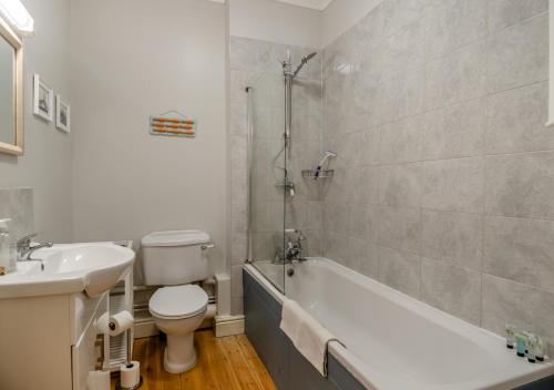 ein Badezimmer mit einem WC, einer Badewanne und einem Waschbecken in der Unterkunft Wagtails in Blythburgh