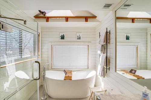 een witte badkamer met een bad en een raam bij Wilmington Retreat with Deck, Lake Views and Game Room in Wilmington