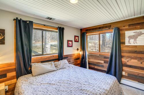 een slaapkamer met een bed in een kamer met houten wanden bij Wilmington Retreat with Deck, Lake Views and Game Room in Wilmington