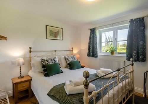 - une chambre avec un lit et une fenêtre dans l'établissement Gardeners Cottage, à Bealings
