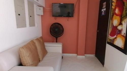 baño pequeño con aseo y TV en la pared en ALIIKA HOTEL, en Albania