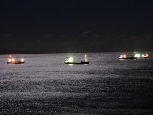 three boats floating in the water at night at Shimoda Prince Hotel in Shimoda