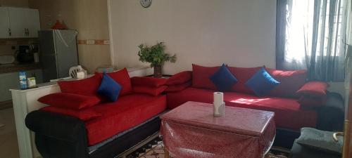 a living room with a red couch and blue pillows at Tranquil Oasis in the Heart of Ifrane in Ifrane