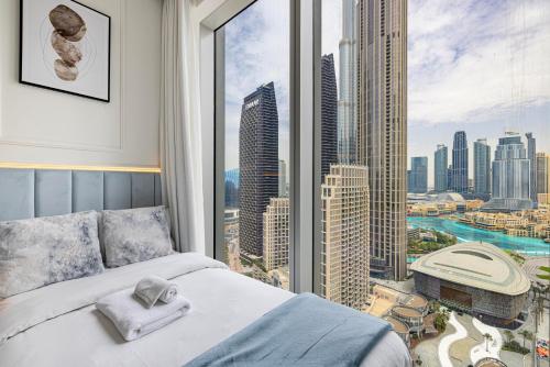 a bedroom with a large window with a view of a city at Luxury 4BR Burj Khalifa & Fountain Views in Dubai