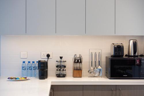 a kitchen with a counter top with a microwave and appliances at Luxury 4BR Burj Khalifa & Fountain Views in Dubai
