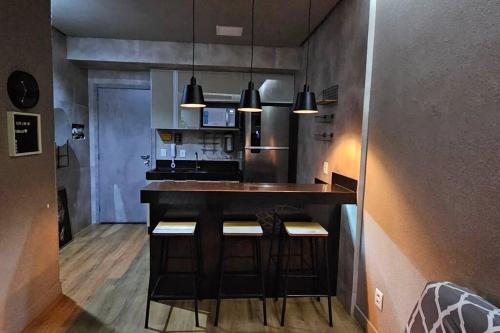 a kitchen with a bar with stools in it at Apartamento de luxo no centro in Belém