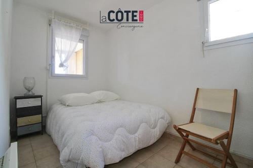 a bedroom with a bed and a chair and a window at Fidji bis in Sausset-les-Pins