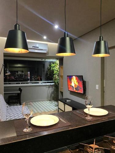 a kitchen with two tables and two wine glasses at Apartamento de luxo no centro in Belém