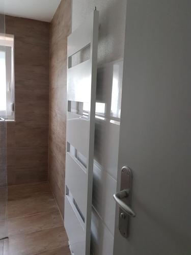 a sliding glass door in a bathroom with wooden walls at Sonnige 3 Zimmer Ferienwohnung Sun Mountain in Rechberghausen