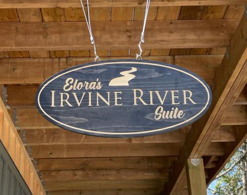 a sign hanging from the ceiling of a wooden building at Elora’s Irvine River Suite in Elora