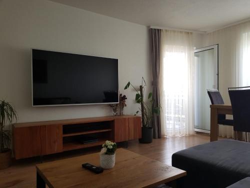a living room with a flat screen tv on the wall at Sonnige 3 Zimmer Ferienwohnung Sun Mountain in Rechberghausen